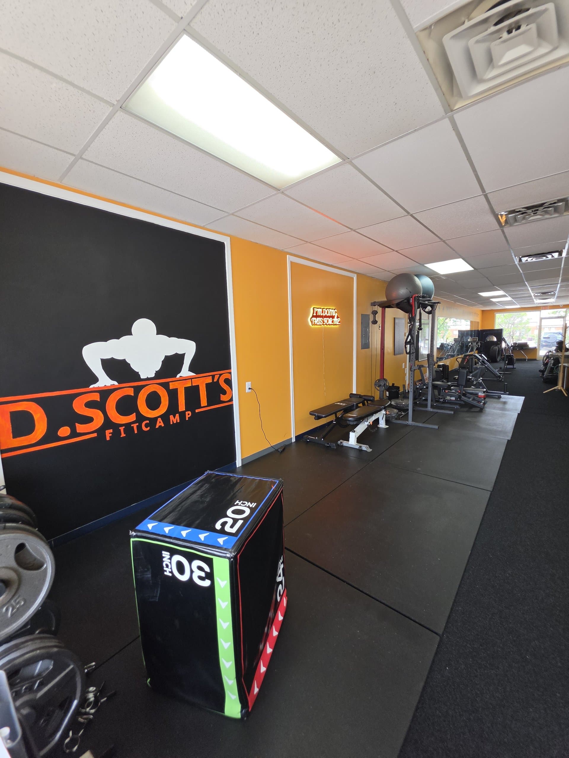 The DScottsFitCamp logo wall and training equipment in Newport News